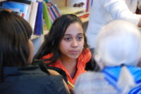 girl listens intently to senior volunteer