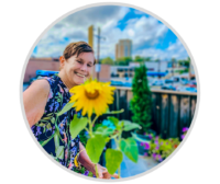 woman smiling at a sunflower
