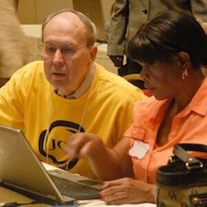 woman helps man with computer