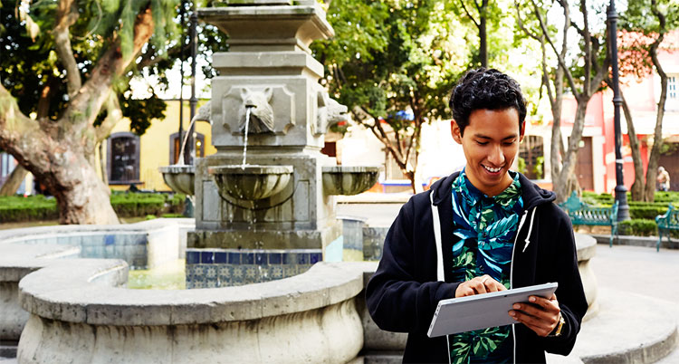 Photo of a student using a tablet outdoors