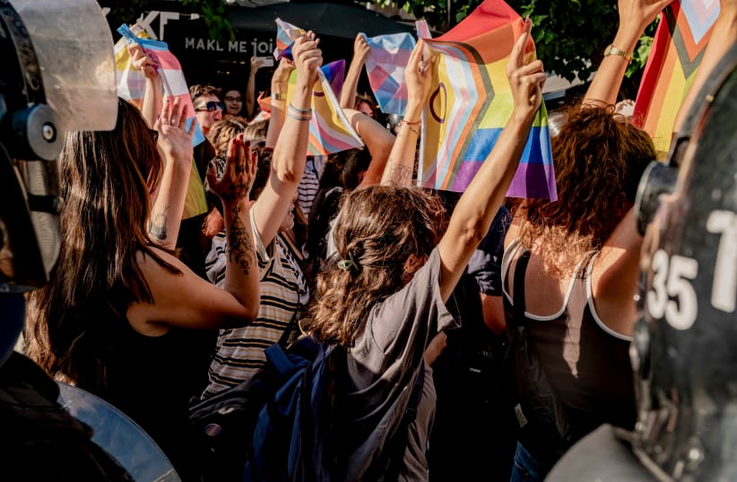 Protesters hold up Pride flags as they stand in front of riot police officers in Izmir, Turkey, on June 27, 2026.