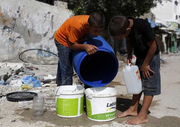 Palestinian children in Gaza fetch water from a container