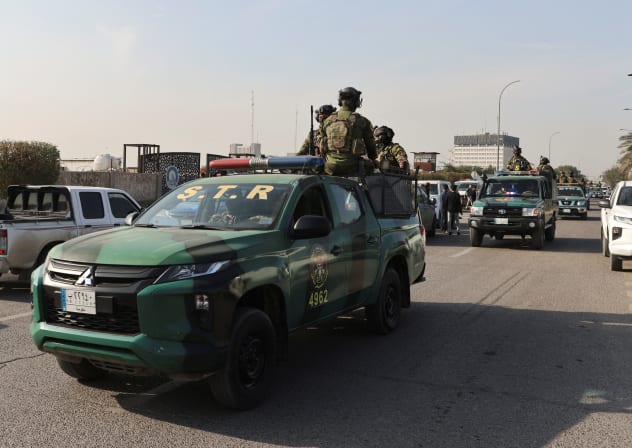  Iraqi security forces sit on vehicles at a street after an attack by a drone strike on an Iran-backed militia headquarters in Baghdad, Iraq January 4, 2024.