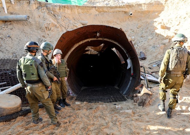 IDF soldiers stand at the entrance of a tunnel that Hamas used to attack Israel, in Beit Hanun, December 17, 2023