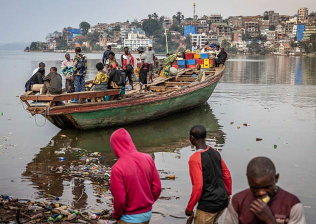 Families sail in a boat as it departs for Minova from a pirogue dock on the shores of Lake Kivu in Bukavu on February 21, 2025.