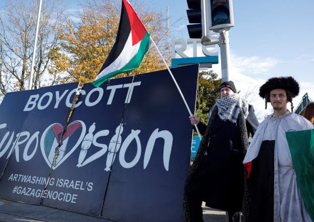Pro-Palestinian protestors hold a flag and a banner outside the RTE (Radio Telefis Eireann) Irish public service broadcaster television studios as demonstrators call for an Irish boycott of the 2026 Eurovision Song Contest if there is Israeli participation, in Dublin, Ireland, November 1, 2025. 