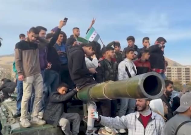 Syrian citizens celebrating fall of the Assad regime, staying on abandoned government army tank in Damascus, December 11, 2024.