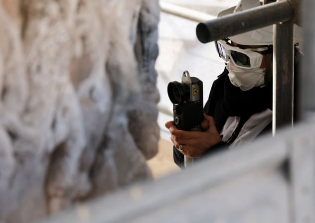 A worker uses a laser to clean a section of the Column of Marcus Aurelius during restoration work, in Rome, Italy, December 18, 2025. 