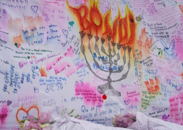 The ink on a memorial message sheet bleeds after rainfall as people lay flowers and pay tribute to honour the victims of a mass shooting during a Jewish Hanukkah celebration at Bondi Beach on December 14, in Sydney, Australia, December 20, 2025.
