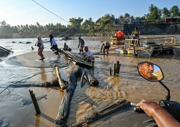 People wait use a rope ferry to cross the Peusangan River following flash floods that destroyed adjacent villages in Bireuen district, Indonesia's Aceh province on January 5, 2026.