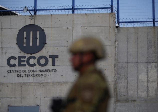 A Salvadoran soldier stands guard, as the CECOT logo is seen, during a media tour at the Terrorism Confinement Center (CECOT) prison, in Tecoluca, El Salvador April 4, 2025.