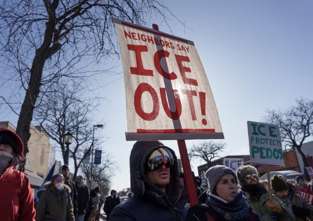 Demonstrators carry signs condemning Immigration and Customs Enforcement (ICE) near the site where a man identified as Alex Pretti was fatally shot by federal agents trying to detain him, in Minneapolis, Minnesota, US, January 24, 2026.