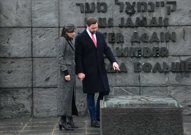 US Vice President JD Vance (R) and his wife Usha Vance (L) visit the gravestone with the ashes of an unknown prisoner and the wall with the inscription "Never again" in five languages, during a tour of the Dachau Concentration Camp memorial site in Dachau, southern Germany, on February 13, 2025.
