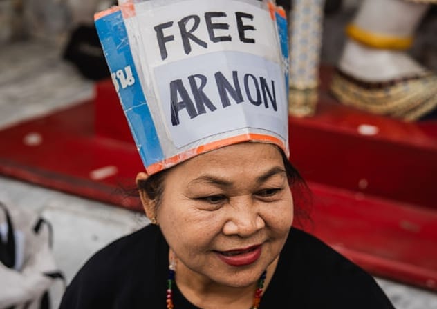 BANGKOK, THAILAND - 2025/07/15: A woman wears a handmade hat reading "Free Arnon" during a vigil, calling for the release of detained human rights lawyer Arnon Nampa.