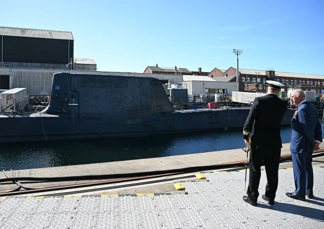 Britain's King Charles talks with Commanding Officer David Crosby during commissioning ceremony for HMS Agamemnon, an Astute-class nuclear-powered submarine, at BAE Systems' shipyard in Barrow-in-Furness, Britain, September 22, 2025.