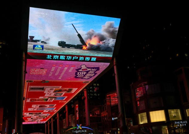 FILE PHOTO: A military aircraft is seen on a giant screen showing news footage about joint army, navy, air and rocket forces drills around Taiwan by the Chinese People's Liberation Army (PLA), outside a shopping mall in Beijing, China, April 1, 2025. 