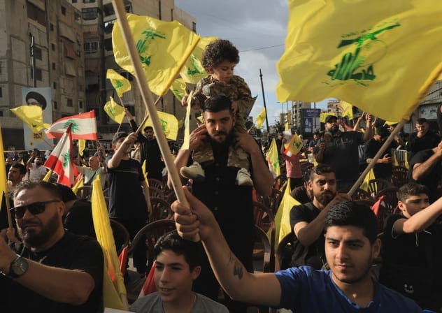 Supporters of Lebanon's Hezbollah wave flags while commemorating Israel’s withdrawal from southern Lebanon in 2000, in the southern suburbs of Beirut, Lebanon, May 25, 2026. 