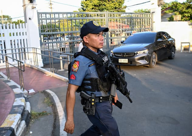 An armed policeman walks past the main gate of the Senate during a lockdown at the Senate premises in Manila on May 11, 2026 as NBI agents try to serve an International Criminal Court (ICC) arrest warrant on former Philippines national police chief and now sitting Senator Ronald Dela Rosa. 