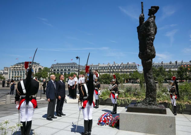  France's President Emmanuel Macron and Charles Dreyfus grandson of Alfred Dreyfus pay tribute in front of the 3.5-meter (12ft) bronze statue made in 1985 by French artist Louis Mitelberg aka Tim.