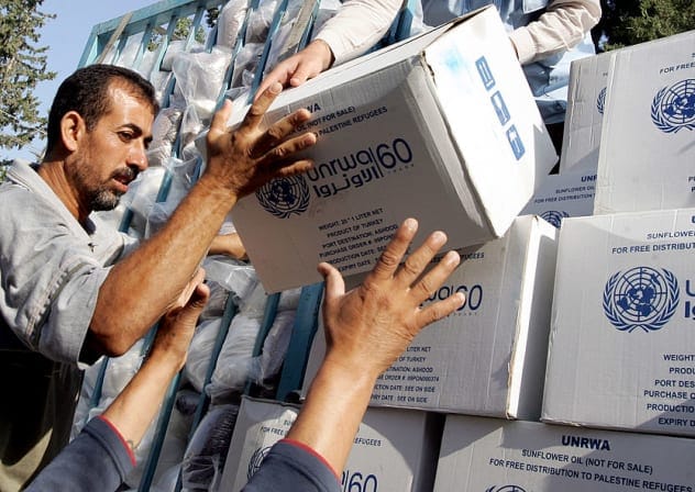 Palestinians receive food aid donated for refugees from the European Union and the World Food Programme (WFP) and distributed by the United Nations Relief and Works Agency (UNRWA) in the northern West Bank city of Jenin, on July 9, 2010.