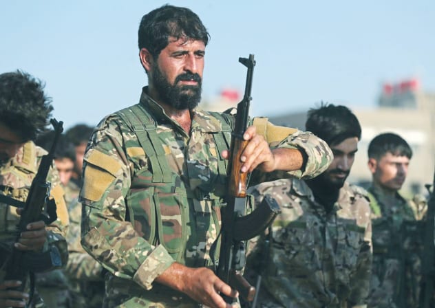 KURDISH FIGHTERS from the Qamishli Brigade on parade last month.