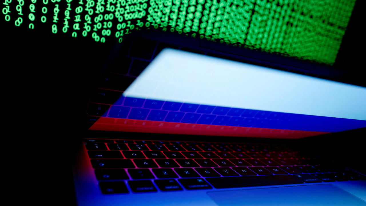  A Russian flag is seen on the laptop screen in front of a computer screen on which cyber code is displayed, in this illustration picture taken March 2, 2018.