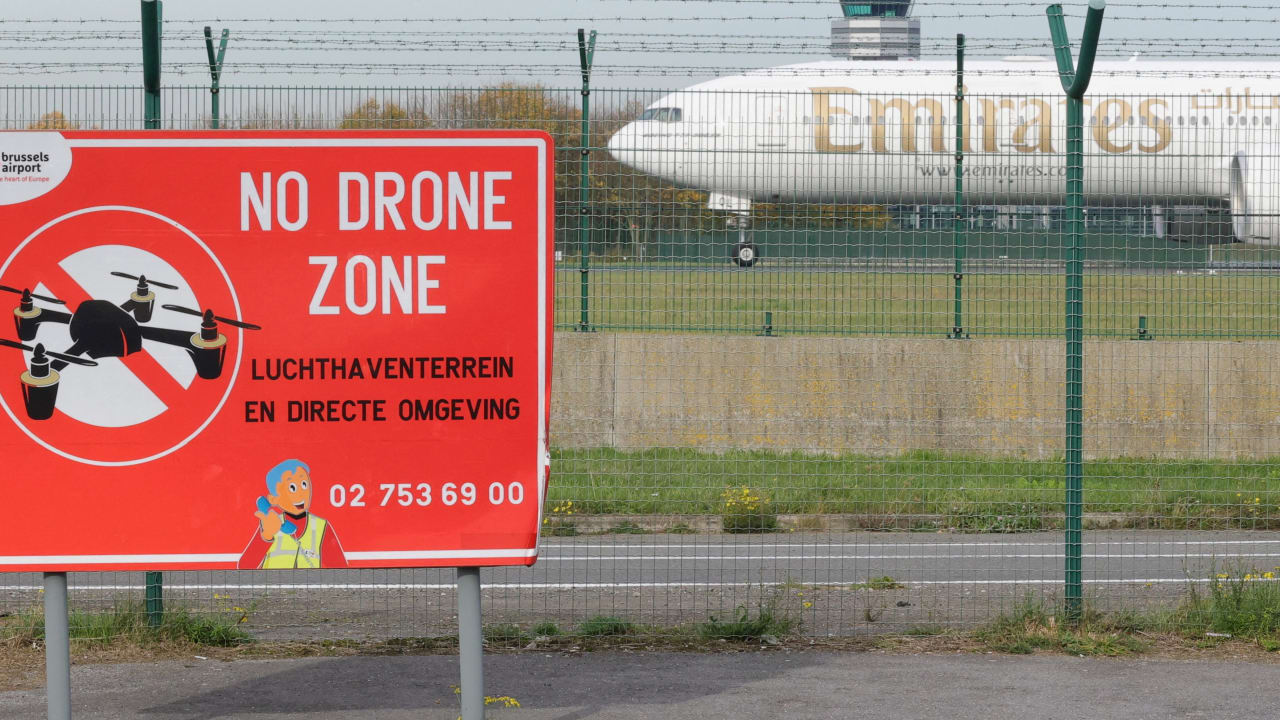 An aircraft lands on the tarmac near a "No Drone Zone" placard on the day of an emergency meeting of Belgian government officials and experts, following drone sightings that closed Brussels Airport, at Brussels international Airport in Zaventem, Belgium, November 6, 2025.