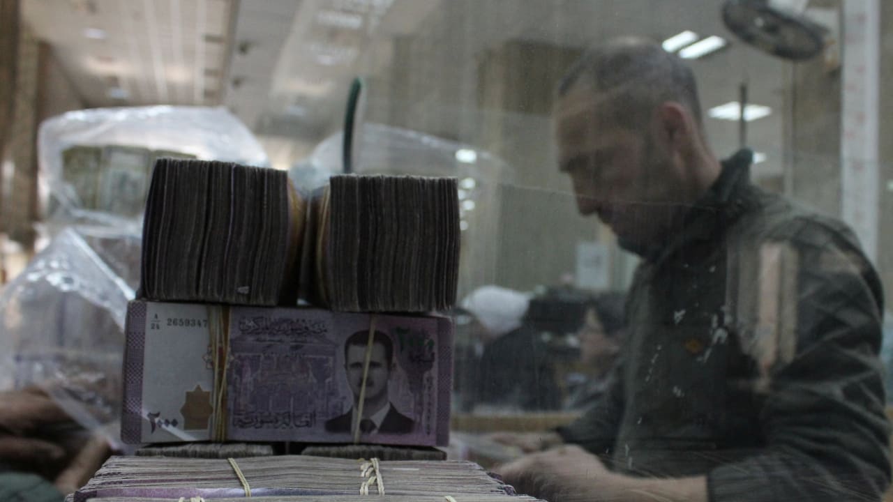 Bundles of Syrian currency notes are stacked up as an employee counts money at Syrian central bank, after the ousting of Syria's Bashar al-Assad in Damascus,Syria, January 12, 2025.