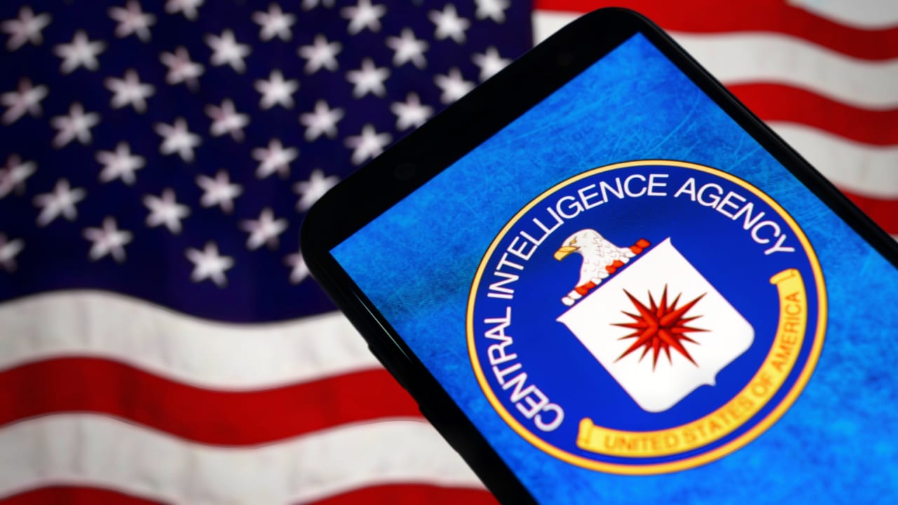 A graphic showing a Central Intelligence Agency logo on a phone in front of a US flag.