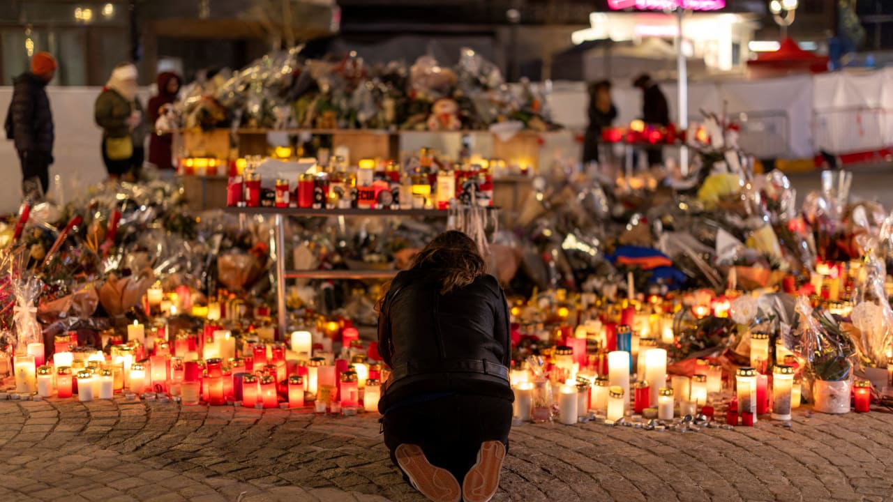A woman lights a candle at a makeshift memorial outside the "Le Constellation" bar, after a deadly fire and explosion during a New Year's Eve party, in the upscale ski resort of Crans-Montana in southwestern Switzerland, January 5, 2026. 