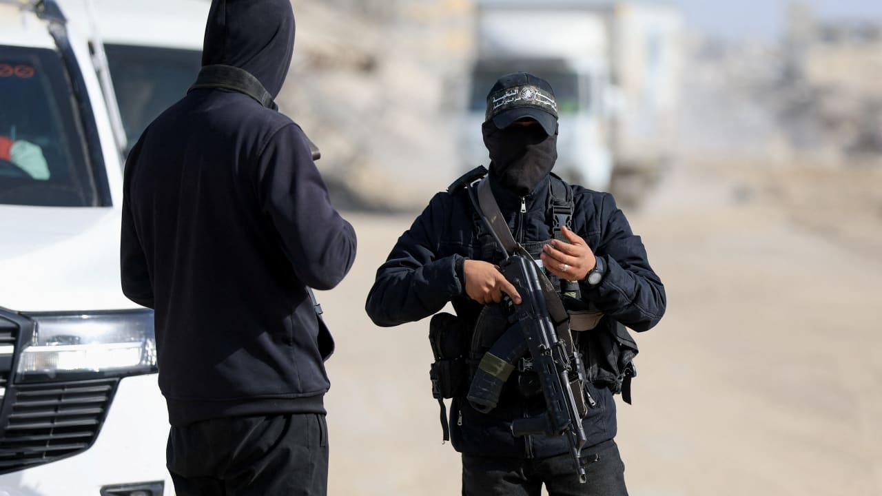 Hamas terrorists stand at a site as Hamas says it continues to search for the body of the last deceased hostage, in Gaza City December 8, 2025.