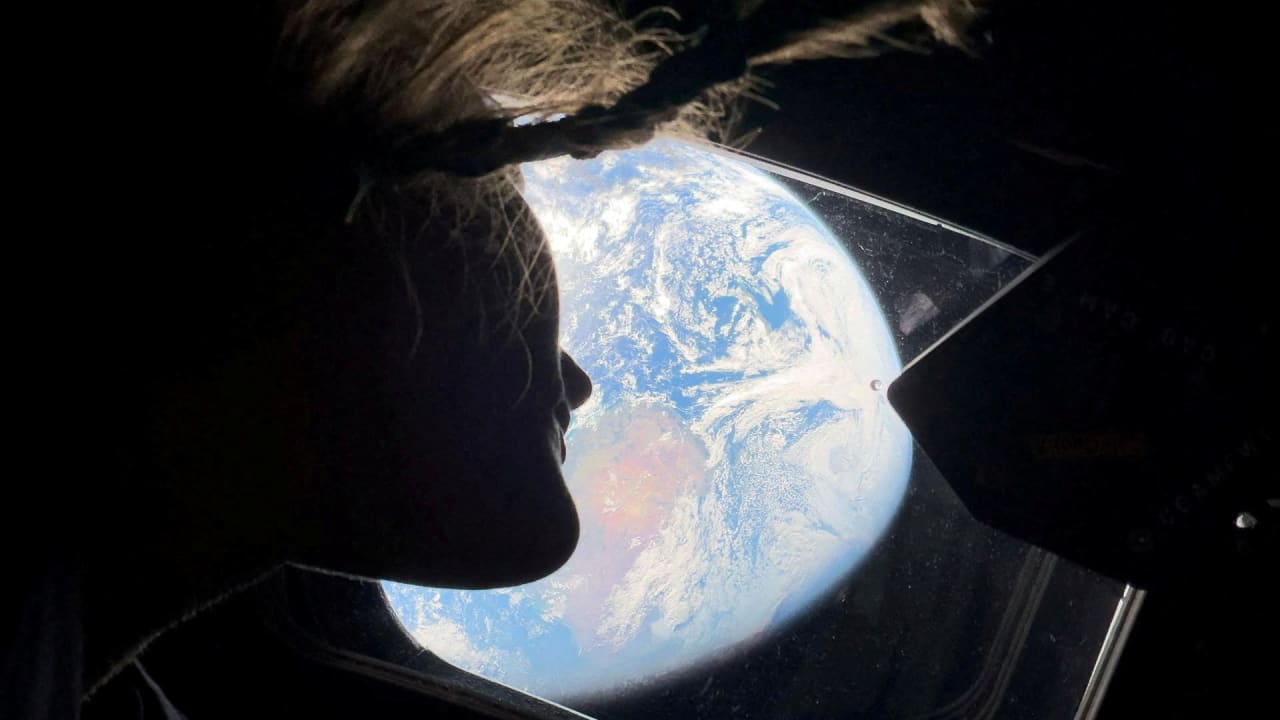 NASA ASTRONAUT and Artemis II mission specialist Christina Koch peers out of one of the Orion spacecraft's main cabin windows, looking back at Earth, as the crew travels towards the Moon April 2, 2026.