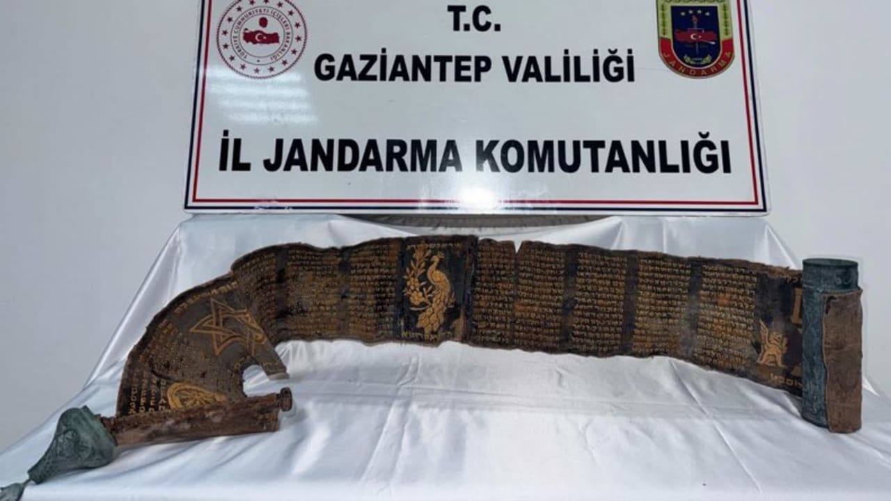 The Hebrew manuscript inscribed in gold on python skin, displayed alongside its copper casing, at the Gaziantep Provincial Gendarmerie Command, April 24, 2026.