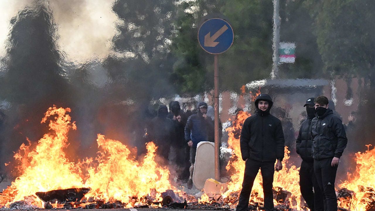 YOUTHS GATHER in front of a burning barricade on Duncairn Gardens on June 9, 2026 in Belfast, Northern Ireland. 