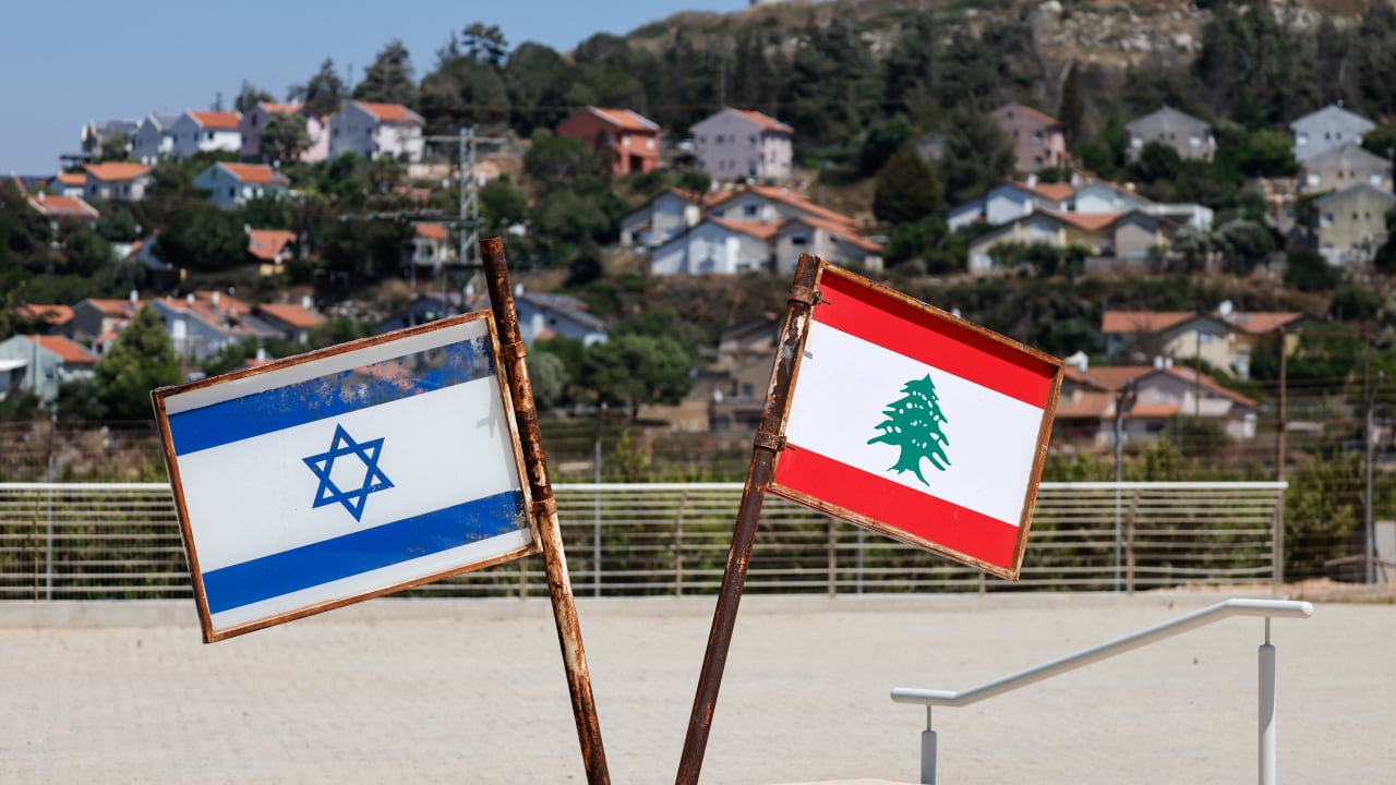 Representations of the Israeli and Lebanese flags at a memorial near the Israel-Lebanon border, as the town of Metula appears in the distance, June 27, 2026