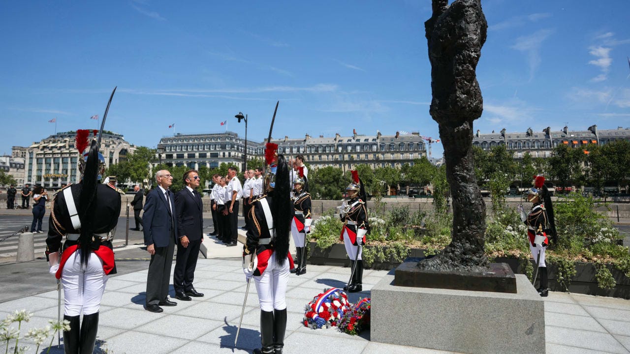  France's President Emmanuel Macron and Charles Dreyfus grandson of Alfred Dreyfus pay tribute in front of the 3.5-meter (12ft) bronze statue made in 1985 by French artist Louis Mitelberg aka Tim.