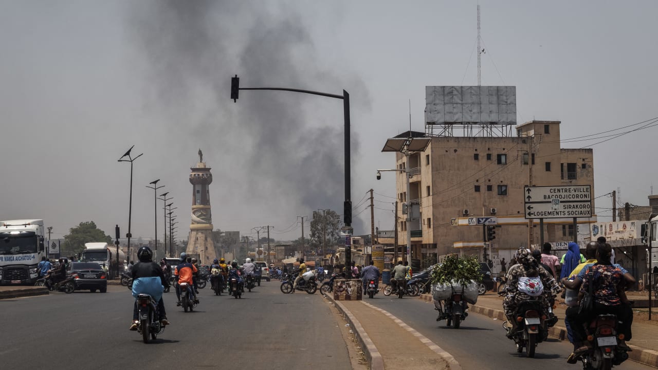 A column of black smoke rises above buildings as traffic passes the Africa Tower monument in Bamako on April 26, 2026; Illustrative.