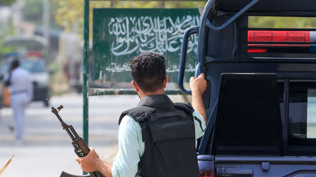 A security officer in plain clothes walks with his gun outside the office of the Rangers, a paramilitary force, following an explosion and gunfire reported on Saturday night in Karachi, Pakistan, June 28, 2026.