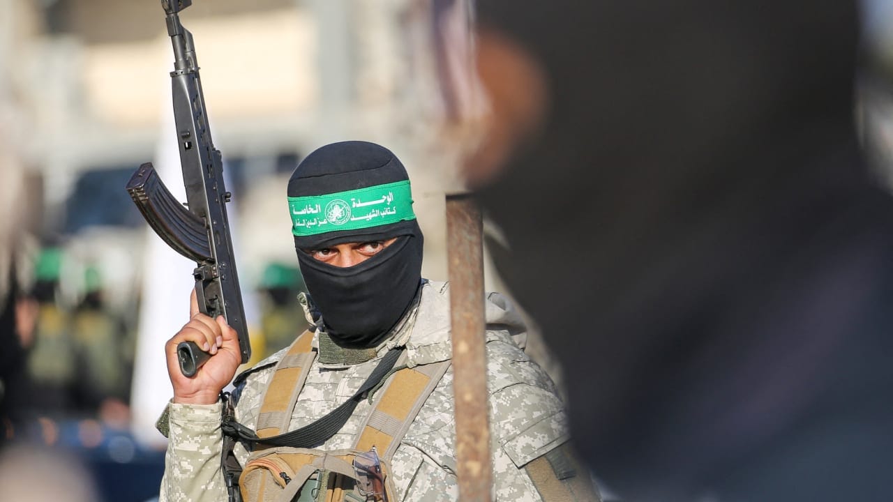 Palestinian militant group Hamas fighters secure an area before handing over two Israeli hostages to a Red Cross team in Khan Yunis.