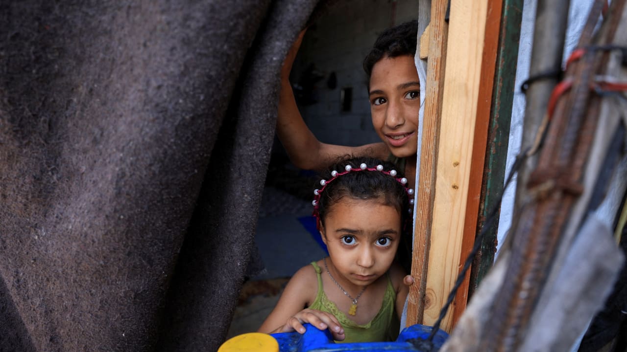 Displaced Palestinian children look out of their shelter in Gaza City, June 15, 2026