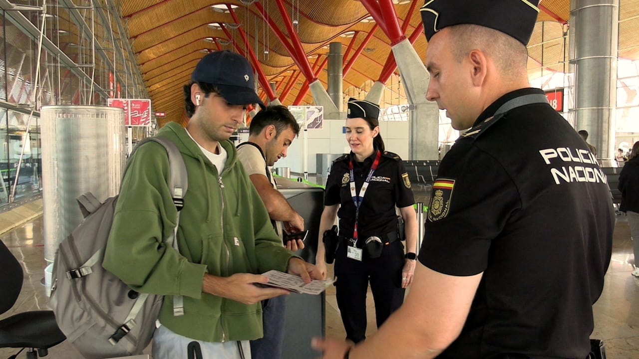 Spanish national police officers check the documents of travellers arriving from Italy, after Spain's government said it would establish border controls for flights and ships from Italy, from midnight on Saturday until September 7, in a dispute over irregular migration, at Madrid-Barajas Airport