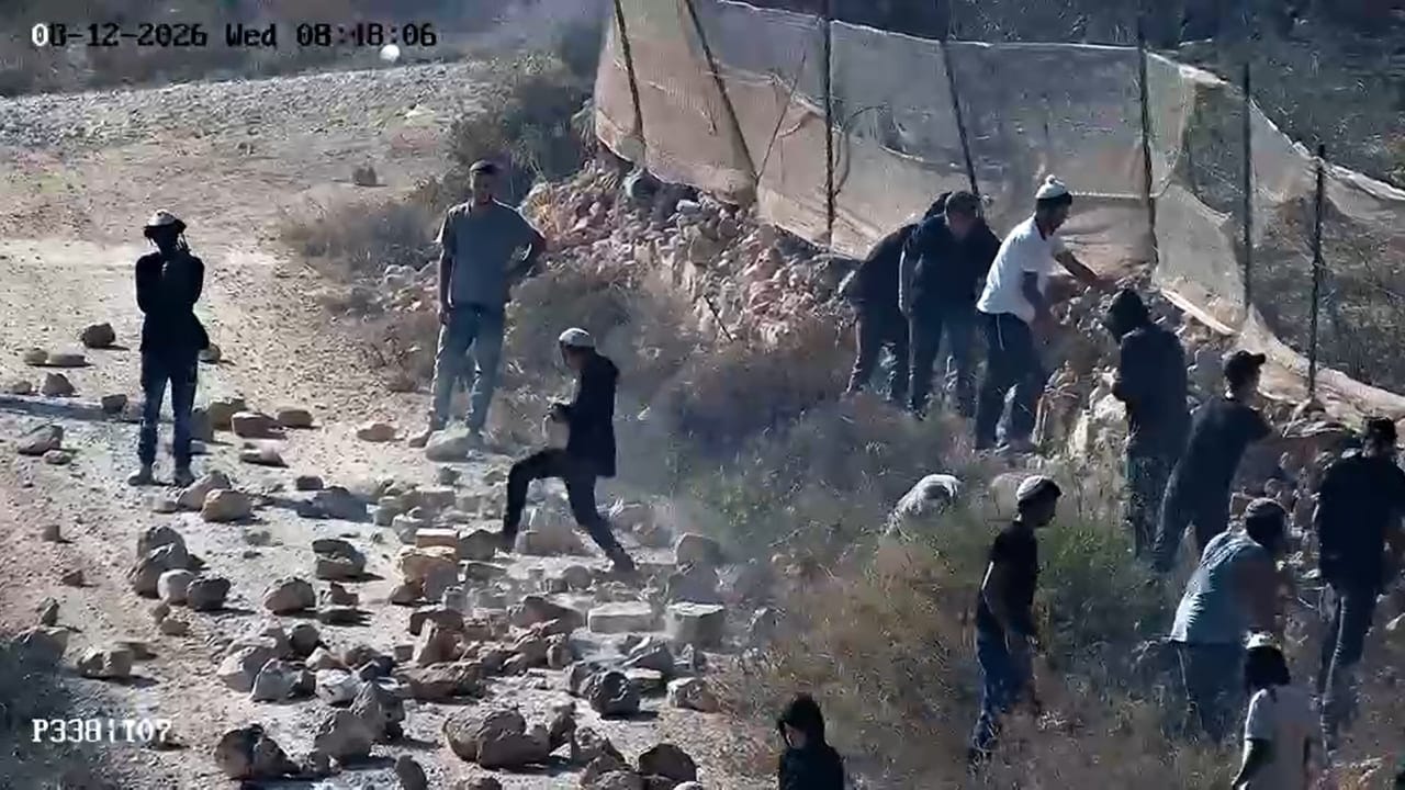 Israeli settler extremists throw stones at a dirt road at the Palestinian village of Kusra, in the West Bank, in an attempt to block the movement of Palestinians and Israeli forces, August 12, 2026