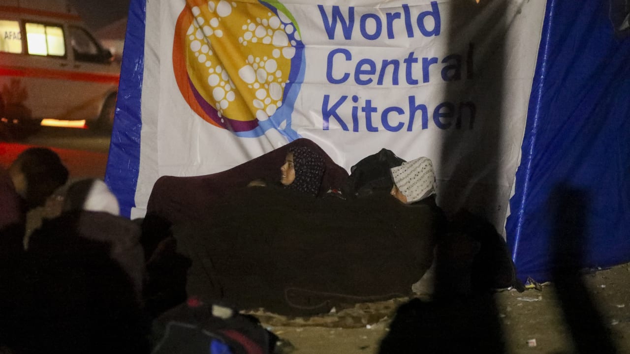 People sit in front of a World Central Kitchen in Deir al-Balah, Gaza Strip, on January 26, 2025.