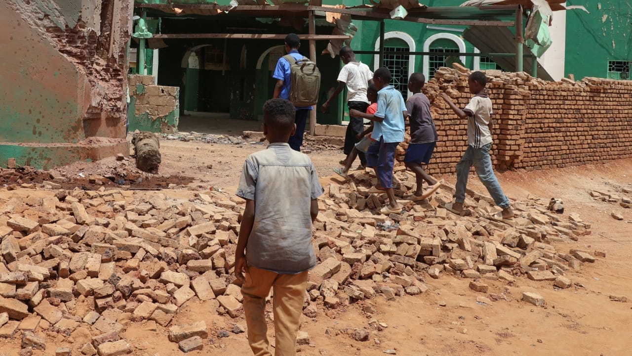 Children walk next to a collapsed mosque wall following a drone strike, in Khartoum North, in Bahri city, Sudan, August 12, 2026. 
