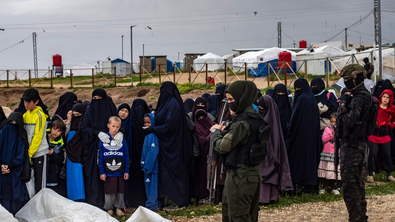Women and children queue during a joint security operation by Syria's Kurdish Internal Security Police Force, also known as Asayesh, and the Kurdish-led Syrian Democratic Forces (SDF) at Camp Roj where foreign relatives of people suspected of belonging to the Islamic State (IS) group are held.