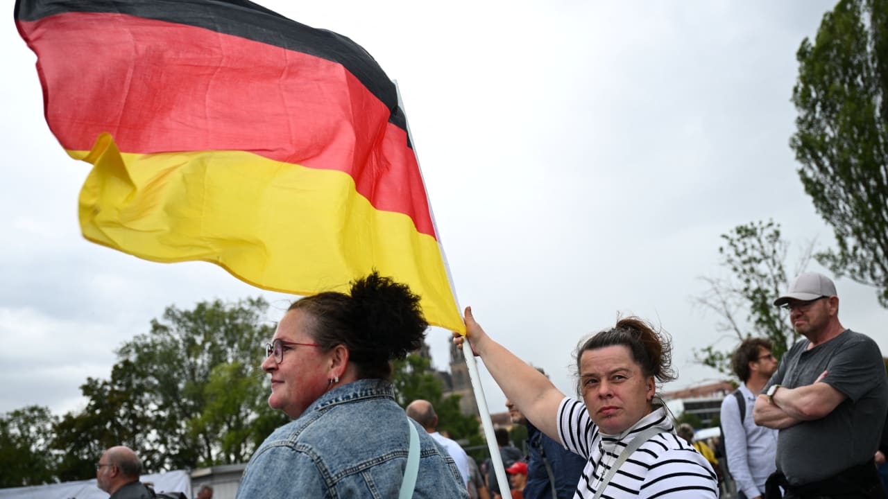 A supporter of the Alternative for Germany (AfD) party holds a German flag as she attends AfD top candidate Ulrich Siegmund's campaign event ahead of the upcoming Saxony-Anhalt state elections in Magdeburg, Germany, September 4, 2026. REUTERS/Annegret Hilse