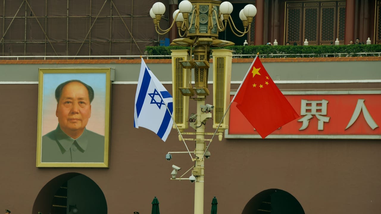 The Israeli and Chinese flags fly beside the portrait of Mao Zedong at Tiananmen Gate in Beijing on May 8, 2013.