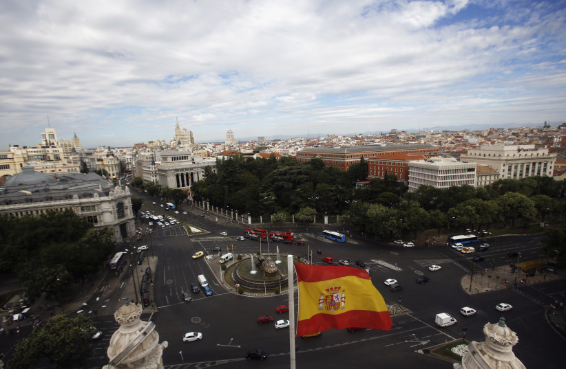 A Spanish flag flutters in the air as the capital of Spain is seen from the observatory deck of Madrid's city hall August 7, 2013.  (credit: REUTERS/SERGIO PEREZ)