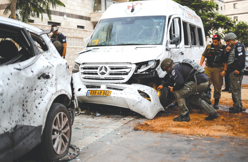  POLICE INSPECT a vehicle that was damaged following a rocket attack from Gaza, in Ashkelon on Saturday. (credit: AMIR COHEN/REUTERS)