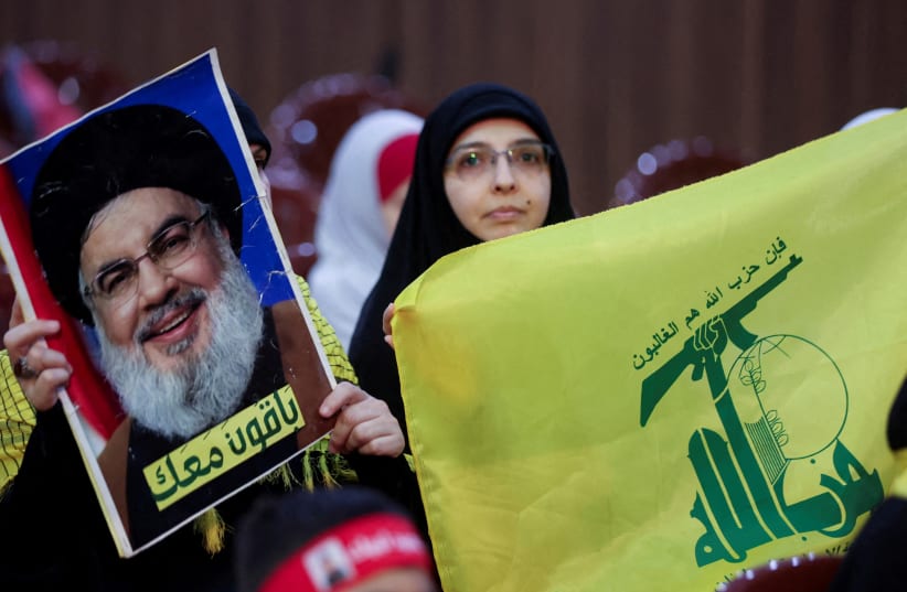  Hezbollah supporters carry a flag and a picture of Hezbollah leader Sayyed Hassan Nasrallah during a rally marking al-Quds Day, (Jerusalem Day) in Beirut's southern suburbs, Lebanon, April 5, 2024.  (photo credit: MOHAMED AZAKIR/REUTERS)